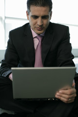 Businessman sitting on the floor and using a laptop