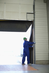 Man standing handling a roller shutter