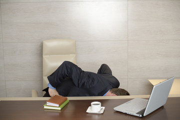 Businessman looking under his desktop
