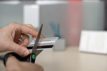 Businessman cutting his credit card in two