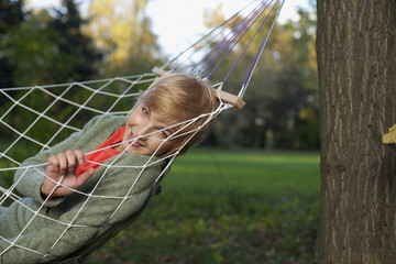 Teenage girl lying in a hammock, close-up, selective focus