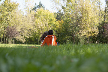 Teenage boy and girl sitting together on a meadow, selective focus