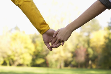 Teenage couple hand in hand (part of), close-up, selective focus