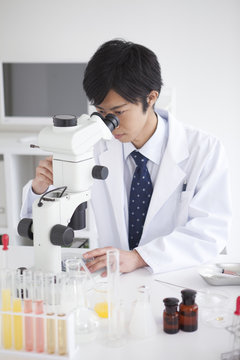 Young Male Scientist Using Microscope in Laboratory