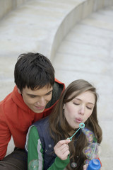 Young couple blowing soap bubbles