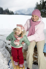 Mother and daughter playing in snow