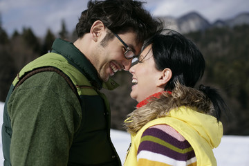 Young couple standing face to face, laughing