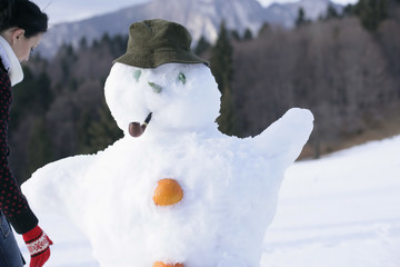 Young woman making a snowman