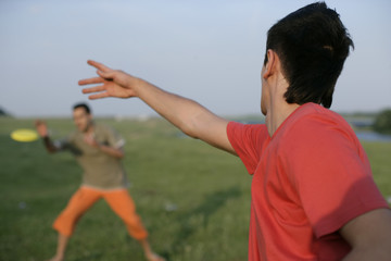Two young men playing with a frisbee