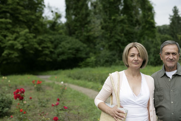 Mature couple walking through a park 