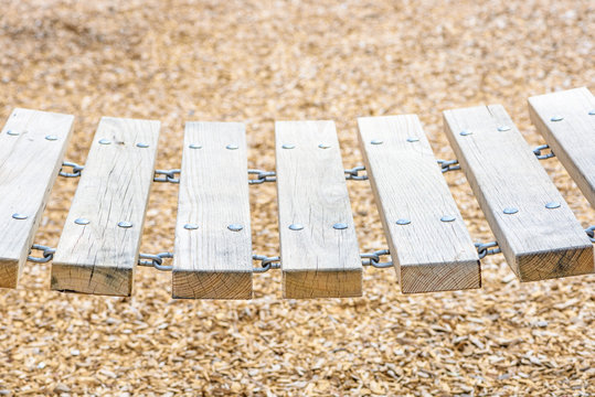 Closeup of a wooden chain bridge in playground sunny day
