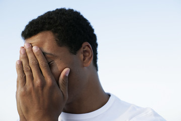 Man covering his face with his hands