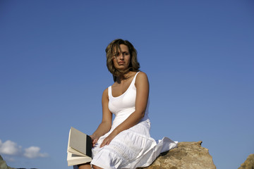 Fototapeta na wymiar Woman sitting on rock with a book