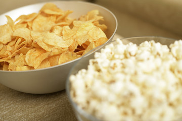 Crisps and popcorn in dishes, close-up