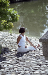 Dark-haired Woman doing physical Exercise at the Shore of a Lake - Yoga - Harmony - Nature