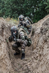 Paratroopers of french 1st Marine Infantry Parachute Regiment RPIMA in entrenchments, pointing to camera front view