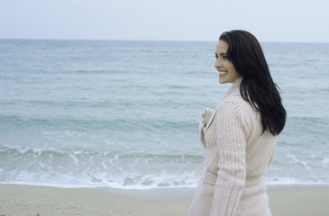 Fototapeta na wymiar Young brownhaired Woman with Cardigan at the Beach - Season - Nature