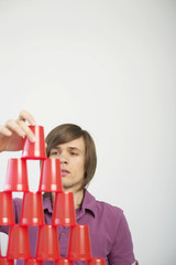 Young man stacking plastic cans