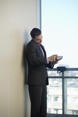 Fototapeta premium Businessman phoning with a mobile phone while reading diary