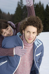 Young woman throwing snow at a man, close-up, selective focus