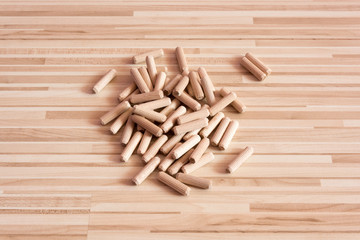 Top view of a grouping of wooden dowels on wooden background