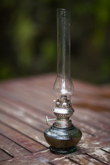 Obraz na płótnie Canvas Kerosene lamp, shield and sword on old wooden table