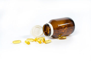 Fish oil capsules with omega 3 and vitamin D in a glass bottle, healthy diet concept,isolated on a white background.