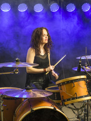 Fototapeta na wymiar Beautiful woman playing drums on stage.