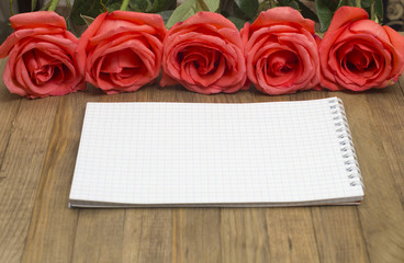 bouquet red pose flowers and  paper notebook