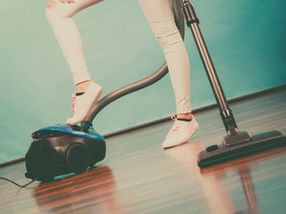 Fototapeta premium Woman legs and vacuum cleaner