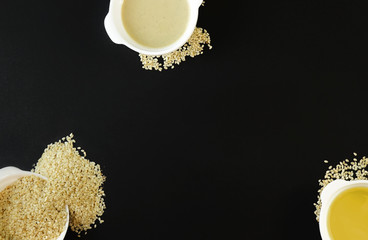Sesame seeds, tahin and sesame oil on black background