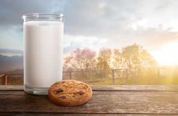 Milk and cookie on wooden table.