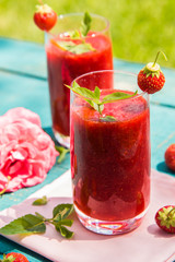 Strawberry smoothies on an old blue wooden surface