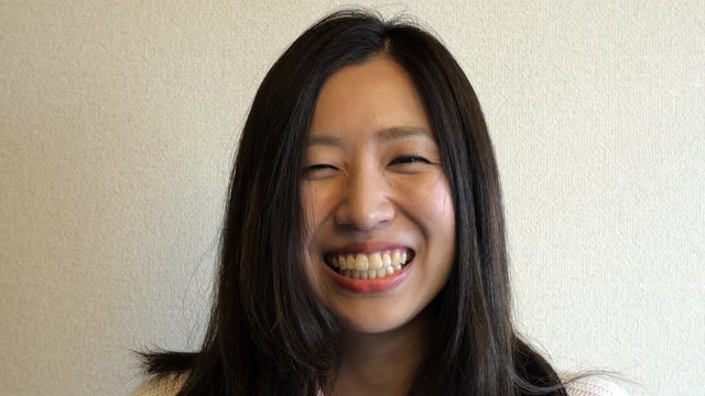 Close up of a cute  Japanese woman laughing.