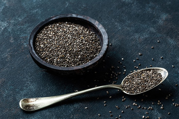 Chia seeds in a stone bowl on a dark background