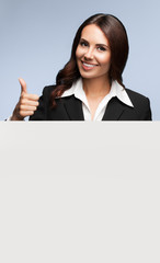 businesswoman showing blank signboard on grey