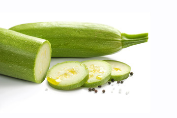 zucchini squash on white background. Sliced drizzled with olive oil
