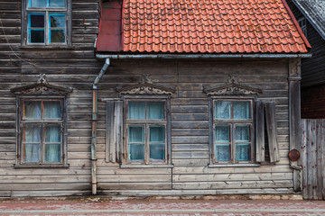 Fototapeta na wymiar Old wooden house with carved windows and decoration in Kuldiga, Latvia