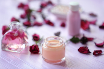 Fototapeta na wymiar Spa concept. Aroma oil, nourishing cream and flowers on white wooden background