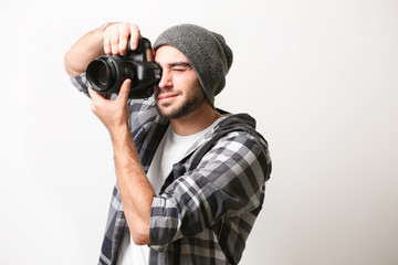 Obraz premium Handsome young photographer on light background