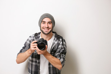 Handsome young photographer on light background