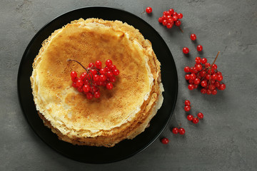 Delicious pancakes decorated with viburnum on plate