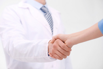 Doctor shaking patient's hand, closeup