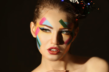 Fototapeta premium Face of beautiful young woman with creative make up on black background