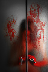 Woman in blood behind shower glass