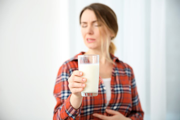 Young woman with milk allergy holding glass in hand