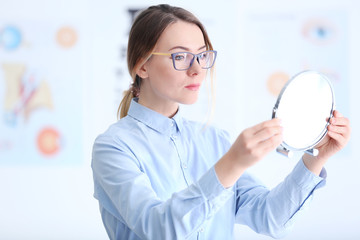 Woman trying on glasses at ophthalmologist