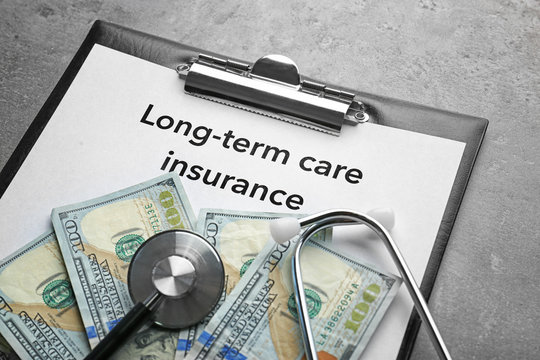 Text LONG-TERM CARE INSURANCE on clipboard with stethoscope and dollars closeup