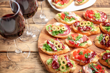 Tasty bruschetta served with wine on table
