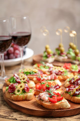 Delicious snack and red wine served on table